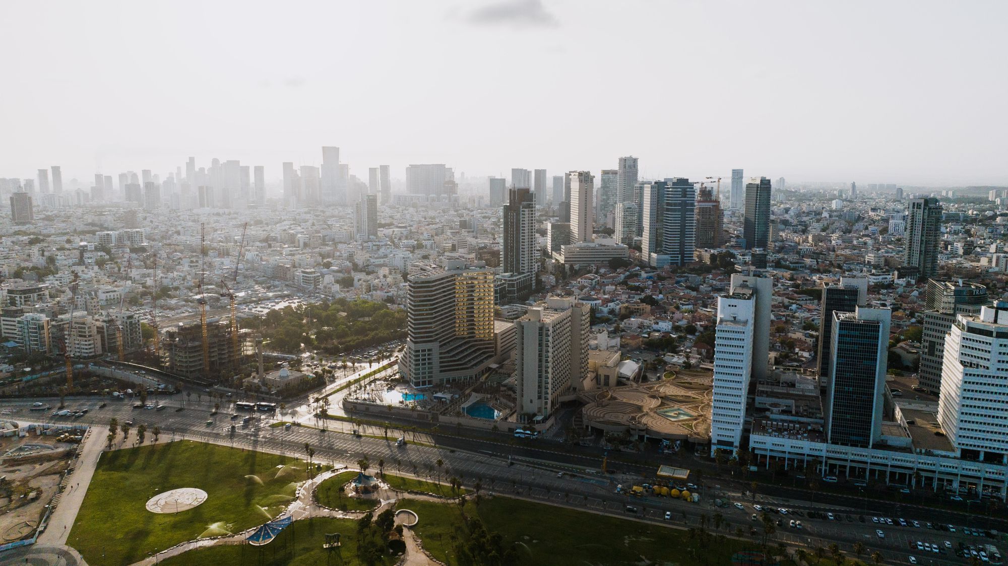 מבט מהאוויר על קו הרקיע של תל אביב עם מגדלים ופארק ירוק
